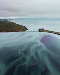 Aerial view of Olfusa River and bridge in South Iceland with flowing pastel hues