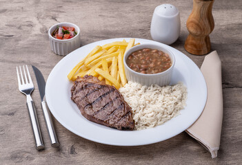 Grilled picanha beef, rice, beans and french fries. Typical brazilian executive dish