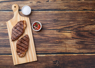 Grilled picanha beef over wooden board with vinaigrette and copy space