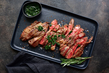 Grilled marbled beef steak on a black plate . Top view with copy space.