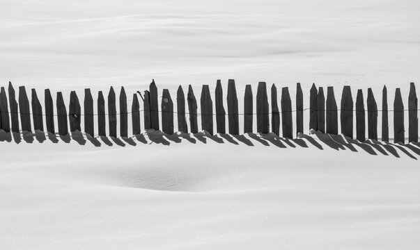 Snow fence casting shadows in monochrome landscape in Georgia