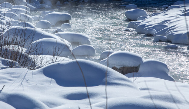 Serene Winter River with Snow-Covered Rocks and Clear Water in Georgia