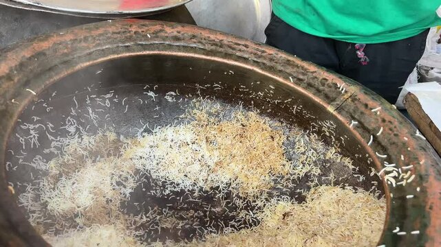 Serving of Kolkata style biryani containing aloo at a shop.