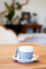 Taza de cafe con una galleta sobre una mesa de madera