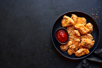 Fresh  homemade crispy chicken nuggets with ketchup.