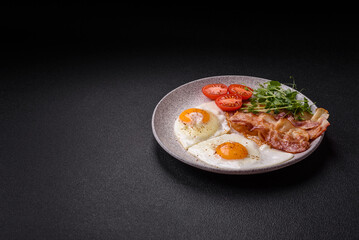 A hearty breakfast with fried eggs, bacon, tomatoes, microgreens