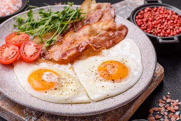 A hearty breakfast with fried eggs, bacon, tomatoes, microgreens