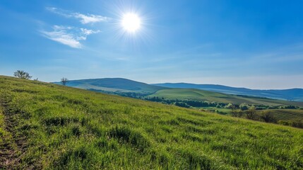 Sunny day over green rolling hills and blue sky landscape