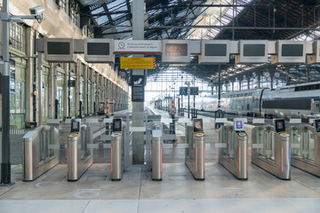 Modern train station entrance with ticket barriers and empty platform