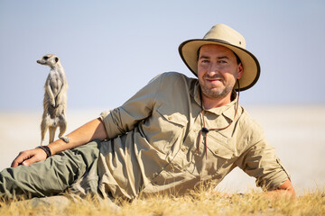 Man on safari with meerkat. © TravelPhotoBloggers