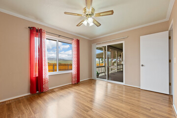 Spacious living room with wooden flooring and sliding doors leading to a bright outdoor area