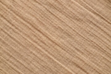 Texture of crumpled linen fabric under natural light in peach fuzz color