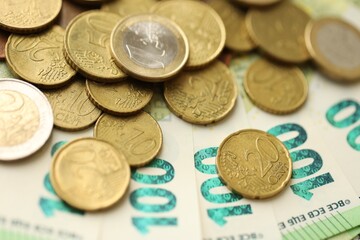 Big amount of euro cent coins lies on hundred euro bills banknotes