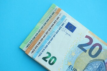 Big amount of one hundred, twenty and fifty euro money bills on blue background