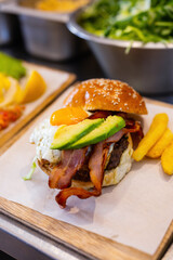 Gourmet burger with fried egg, bacon and avocado