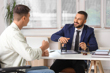 Male lawyer stamping document with client in wheelchair at office