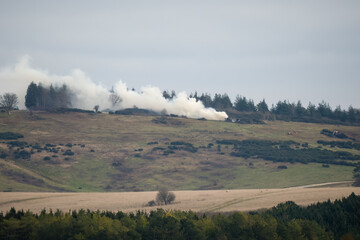 white smoke rising in a winter sky from burning farm manure