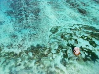 Turquoise waters with a lone rock.