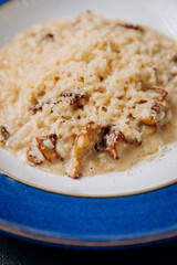 Creamy porcini mushroom risotto served on a blue plate with parmesan garnish