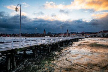 Beautiful old wooden pier in Sopot and stormy sea waves
