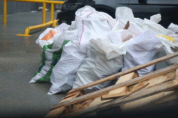 Many white garbage bags full of construction waste