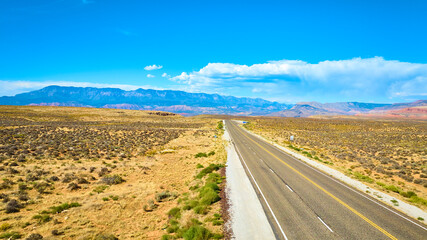 Aerial Highway Through Desert Mountains and Expansive Terrain