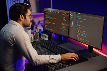 Working smart IT developer analyzing data software development on two pc screen, creating...