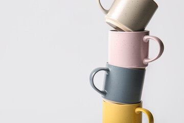 Stack of different ceramic mugs on grey background