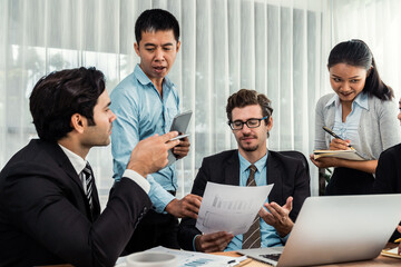 Diverse of business people from various ethnic group working in modern office environment. Productive and multi ethnic office workers engage in discussion for strategic business marketing. Meticulous