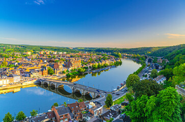 Namur cityscape with Meuse river embankment and Pont de Jambes arch stone bridge, aerial panoramic view of Namur city, skyline horizon with green forests trees on hills, Wallonia Region, Belgium