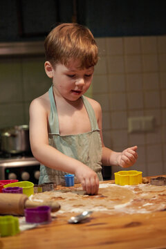 Young child happily making cookies in a cozy kitchen during morning hours