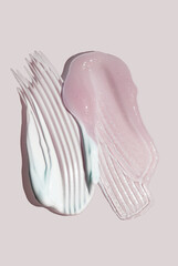 Set of two pink and blue cosmetic products gel (emulsion, serum, balm) and cream (milk, cleanser) smudge pink isolated background