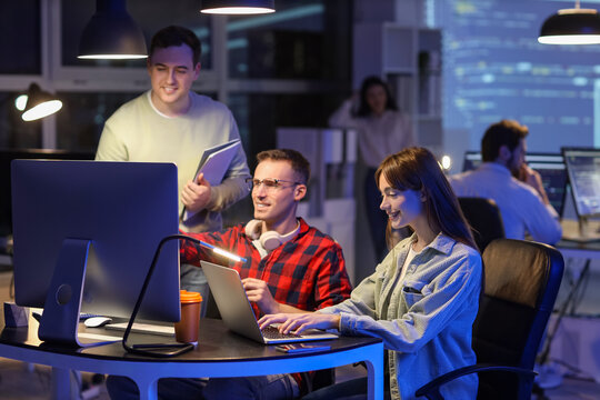 Team of programmers working in office at night