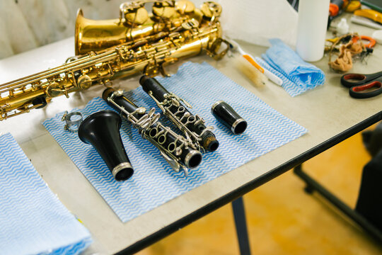 Saxophone and clarinet being repaired on workbench by instrument technician