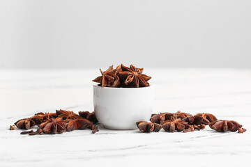 Bowl with anise stars on white background
