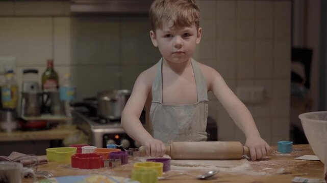 Young child happily baking cookies in a cozy kitchen