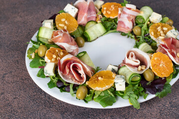 Wreath-shaped salad with jamon, tangerines, arugula, dor bleu cheese and pine nuts