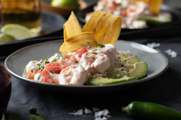 Traditional mexican shrimp ceviche with tomato serrano pepper, Fried banana chips and avocado.