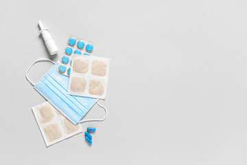 Mustard plasters with medical mask, pills and nasal drops on light background