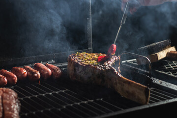Beef steak on the grill with smoke and flames.
