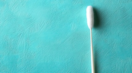 Single cotton swab on teal background.
