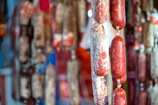 Mostrador de salamis y salchichas colgadas en ferias gastron&oacute;micas
