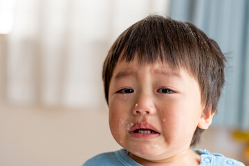 お菓子作り中に泣く子供の顔（男の子、2歳、日本人）
