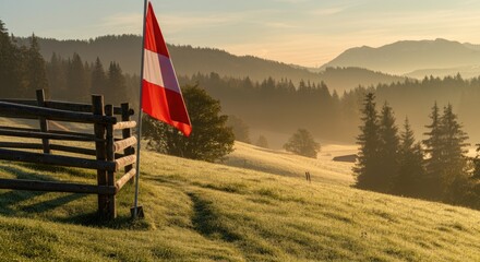 Scenic view of hilly landscape with distant mountains and red-white flag at sunrise
