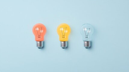 Three pastel colored light bulbs on blue background.