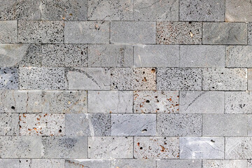 Textured gray stone wall with weathered surface and visible pores