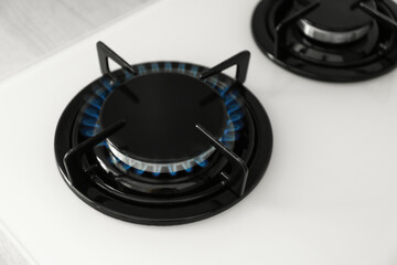 Gas burner of modern stove with burning blue flame, above view