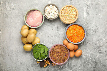 Diet plan for anemia. Different products rich in iron on grey table, flat lay. Space for text