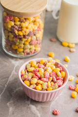 Colorful breakfast cereals in the shape of various fruit in bowl on kitchen table.
