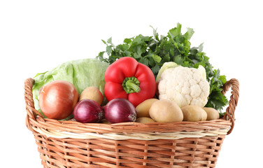 Different ripe vegetables in wicker basket isolated on white